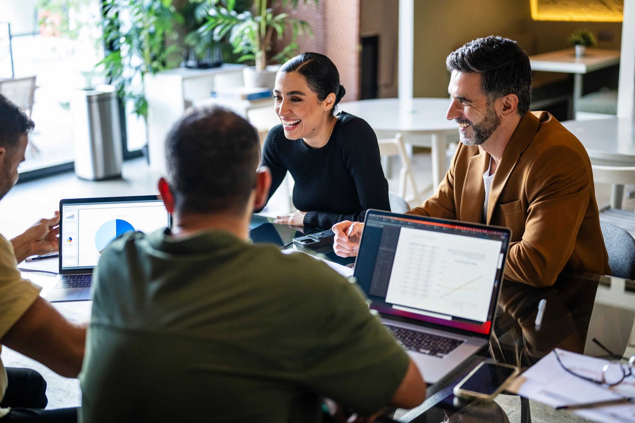 Business colleagues collaborating around a table with laptops